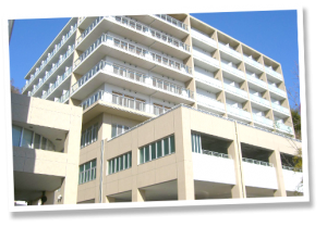 複数階の介護施設建物。白色とベージュ色の外壁が特徴的。